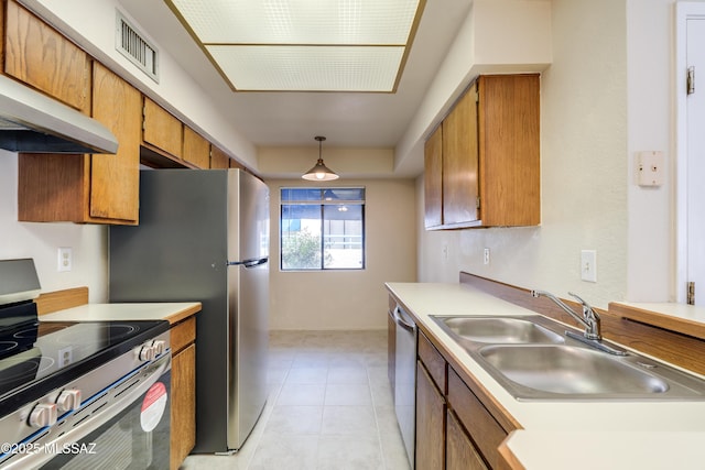 kitchen with a sink, appliances with stainless steel finishes, visible vents, under cabinet range hood, and brown cabinetry