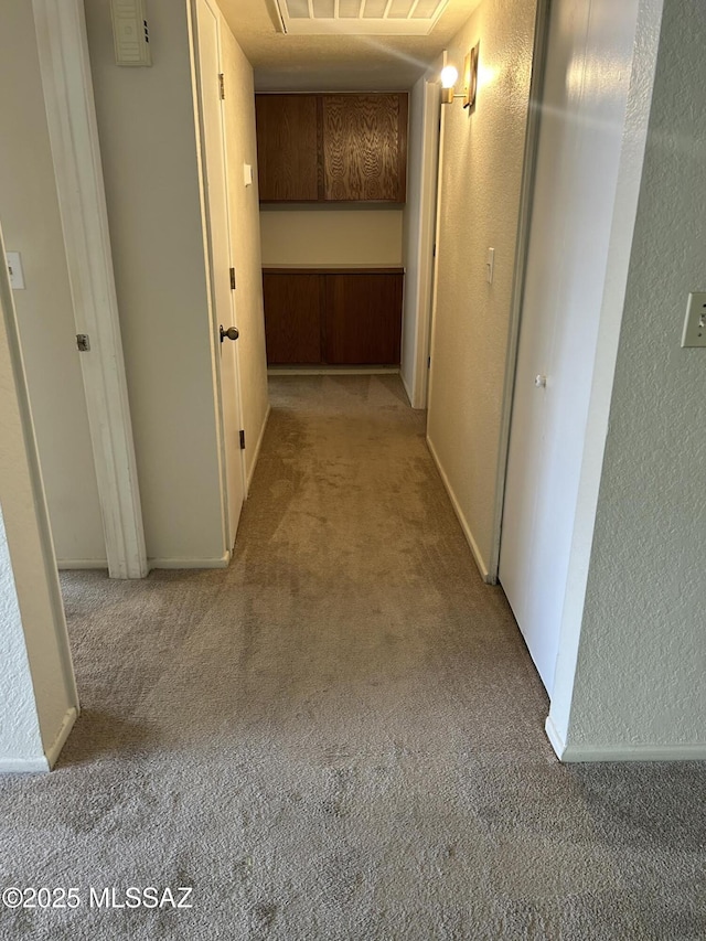 hall with carpet and a textured wall
