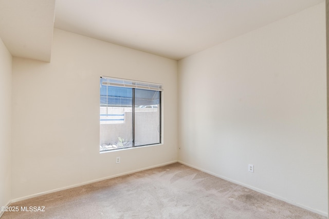 spare room with baseboards and carpet floors