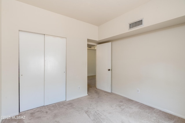 unfurnished bedroom with baseboards, visible vents, a closet, and carpet
