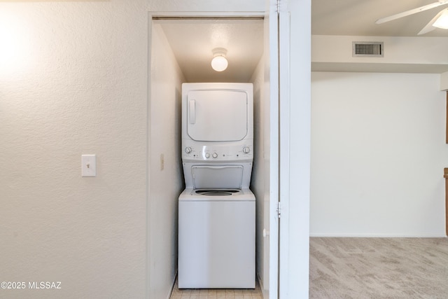 washroom featuring stacked washer / drying machine, ceiling fan, laundry area, visible vents, and carpet floors