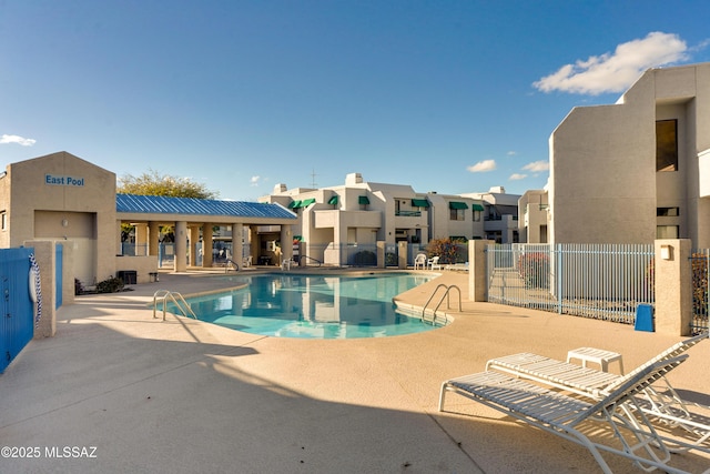 pool with fence, a residential view, and a patio area