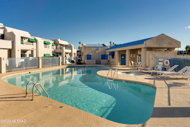community pool with a residential view, a patio, and fence