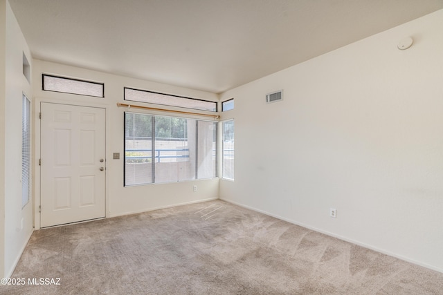 carpeted empty room featuring visible vents and baseboards