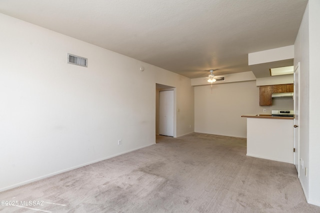 unfurnished living room with a ceiling fan, visible vents, and light colored carpet