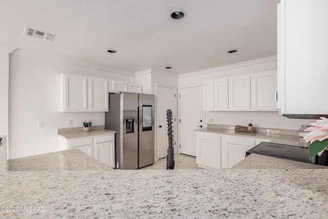 kitchen featuring white cabinetry, crown molding, visible vents, and stainless steel refrigerator with ice dispenser