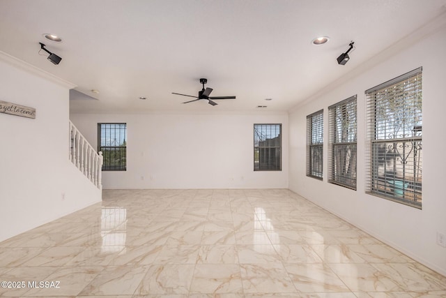 empty room featuring ceiling fan, marble finish floor, and ornamental molding