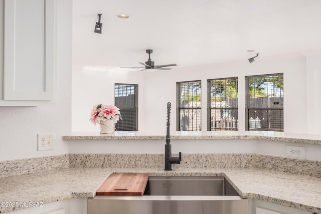 room details featuring a sink, light stone counters, recessed lighting, ceiling fan, and white cabinetry