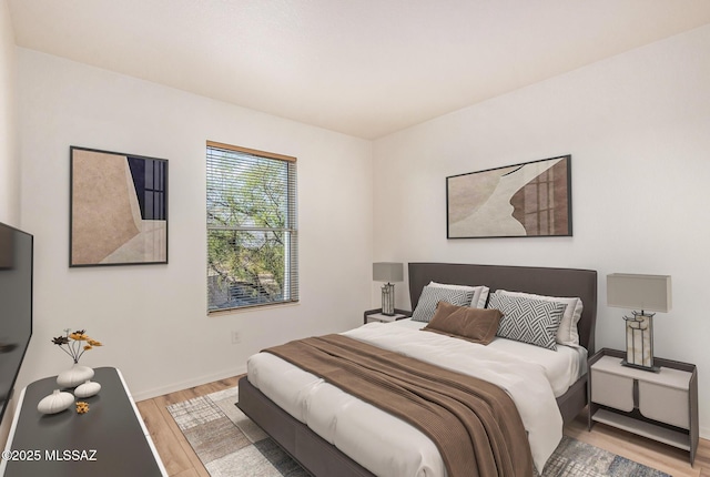 bedroom with light wood-style flooring and baseboards