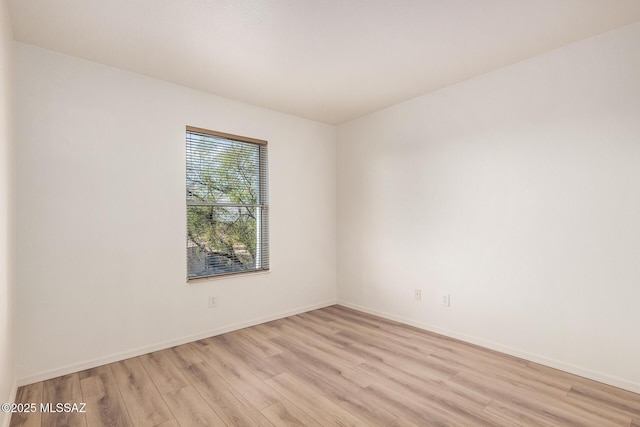 spare room with light wood finished floors and baseboards