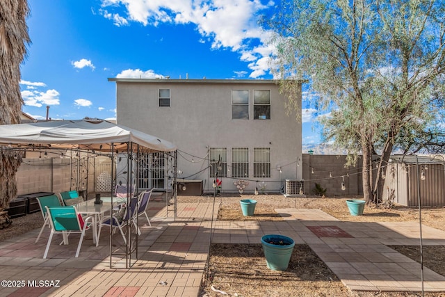 back of property featuring outdoor dining space, cooling unit, a patio, stucco siding, and a fenced backyard