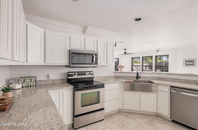 kitchen featuring a ceiling fan, marble finish floor, a sink, white cabinetry, and stainless steel appliances