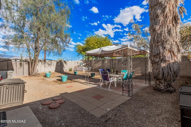 view of patio / terrace with a gazebo, a storage shed, and a fenced backyard