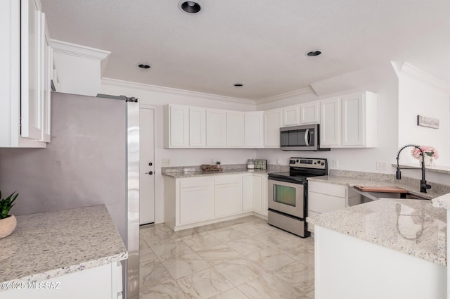 kitchen featuring marble finish floor, stainless steel appliances, white cabinets, and a sink