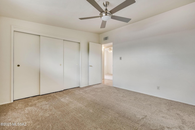 unfurnished bedroom with ceiling fan, carpet flooring, visible vents, and a closet