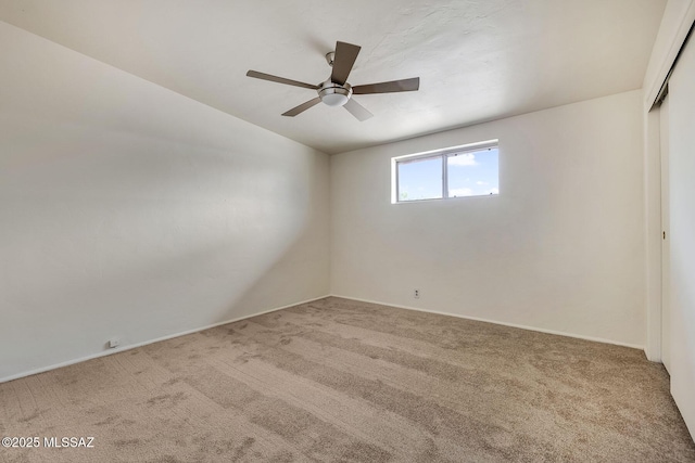 carpeted empty room featuring lofted ceiling, baseboards, and ceiling fan