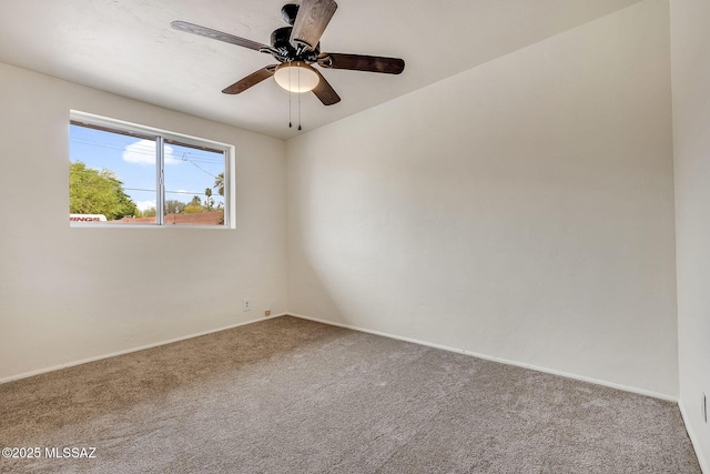 spare room featuring ceiling fan, baseboards, and carpet