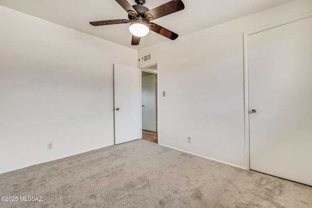 unfurnished bedroom with a ceiling fan, visible vents, and carpet