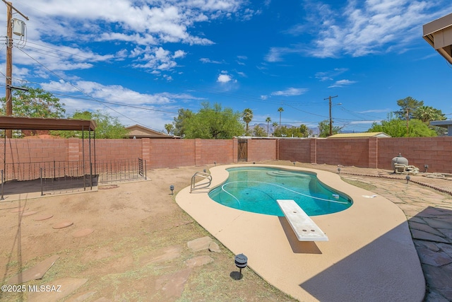 view of pool with a fenced backyard, a diving board, a patio, and a fenced in pool