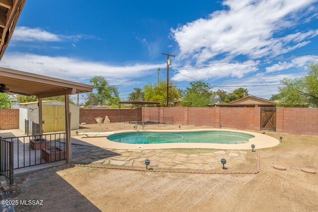 view of swimming pool featuring a fenced backyard, a fenced in pool, a shed, and a patio
