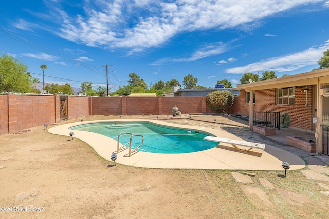view of swimming pool with a fenced in pool, a fenced backyard, a patio, and a diving board