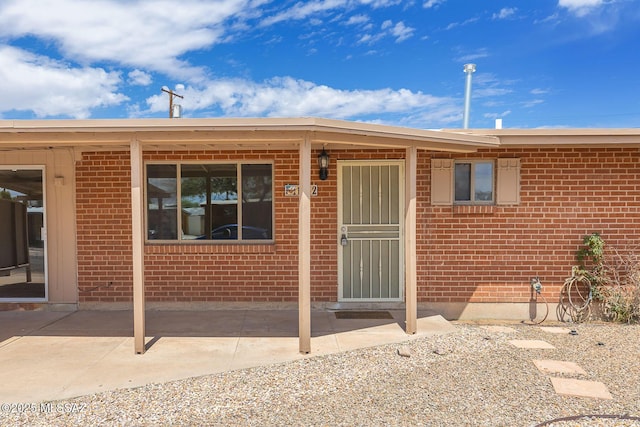 rear view of property with a patio area and brick siding