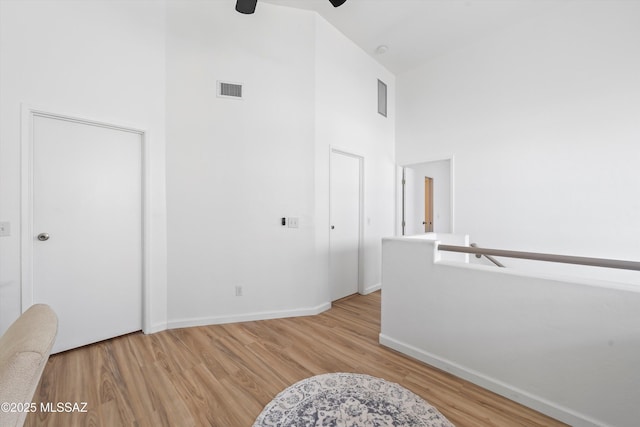 5675 N Camino Esplendora Unit 7-141, Tucson, AZ 85718 - interior space with wood finished floors, a ceiling fan, visible vents, baseboards, and a towering ceiling