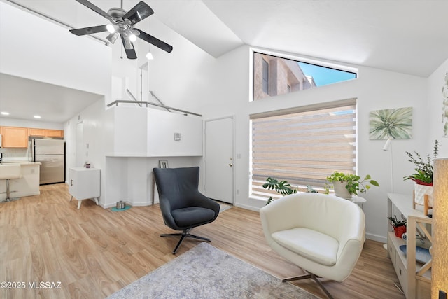 5675 N Camino Esplendora Unit 7-141, Tucson, AZ 85718 - sitting room with light wood-style floors, baseboards, a ceiling fan, and high vaulted ceiling