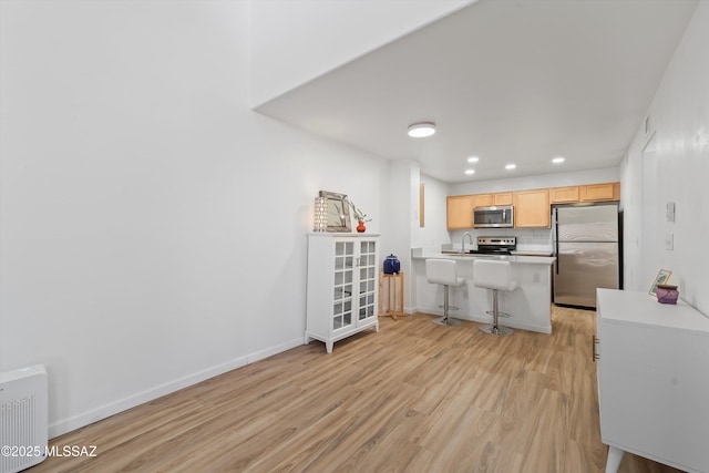 5675 N Camino Esplendora Unit 7-141, Tucson, AZ 85718 - kitchen featuring a peninsula, appliances with stainless steel finishes, a sink, and light wood-type flooring