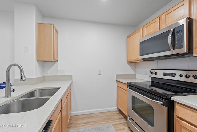 5675 N Camino Esplendora Unit 7-141, Tucson, AZ 85718 - kitchen featuring light brown cabinetry, stainless steel appliances, light wood finished floors, a sink, and light countertops