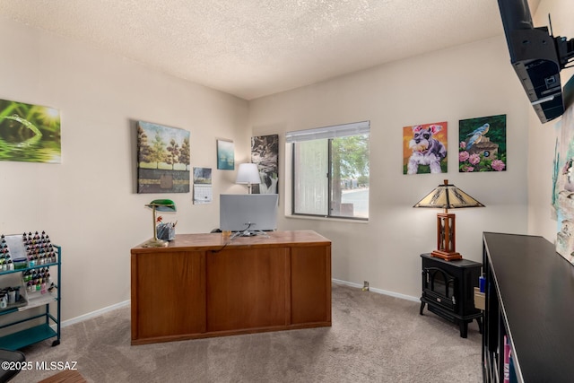 carpeted home office featuring baseboards, a wood stove, and a textured ceiling
