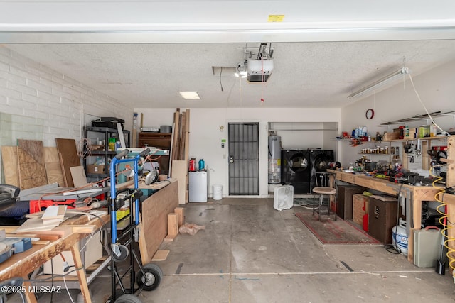 garage featuring a workshop area, a garage door opener, gas water heater, and washer and dryer