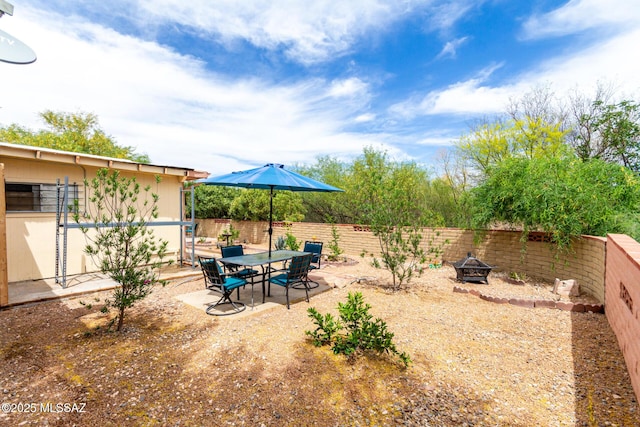 view of yard featuring a fenced backyard, a patio, and a fire pit