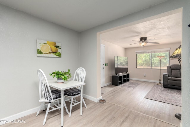 dining space featuring baseboards, ceiling fan, and wood finished floors