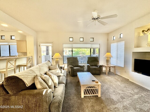 carpeted living area featuring baseboards and ceiling fan