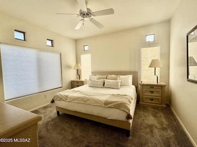 bedroom featuring baseboards, dark carpet, and multiple windows