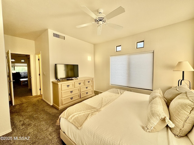 bedroom featuring dark carpet, baseboards, a ceiling fan, and visible vents