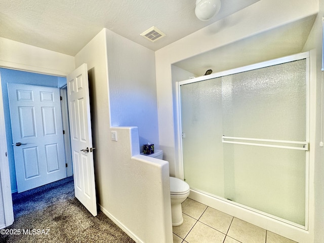 full bath featuring a shower stall, toilet, visible vents, and baseboards