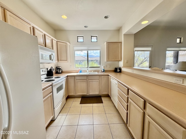 kitchen featuring light brown cabinets, a healthy amount of sunlight, and white appliances