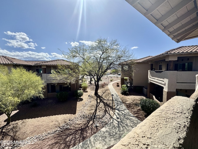 view of side of property featuring stucco siding and a tile roof