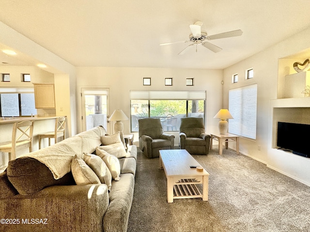 carpeted living area featuring ceiling fan, baseboards, and a fireplace