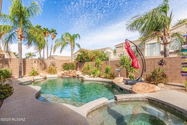 view of pool featuring a pool with connected hot tub and a fenced backyard