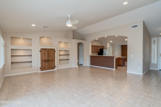 unfurnished living room featuring visible vents, built in features, baseboards, and ceiling fan