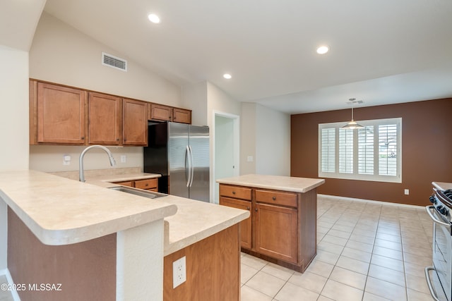 kitchen featuring stainless steel appliances, light countertops, visible vents, and brown cabinets