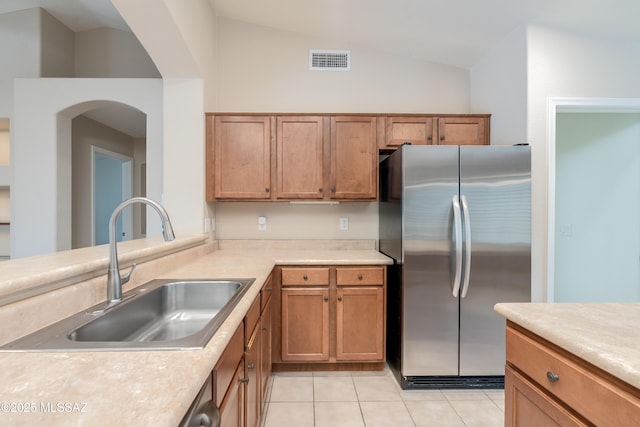 kitchen featuring light countertops, vaulted ceiling, visible vents, a sink, and freestanding refrigerator