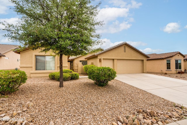 view of front of home with stucco siding, an attached garage, concrete driveway, and a tile roof
