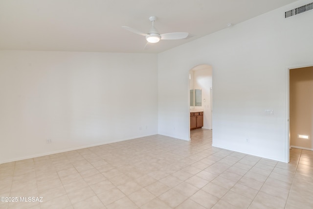 spare room featuring arched walkways, visible vents, and ceiling fan