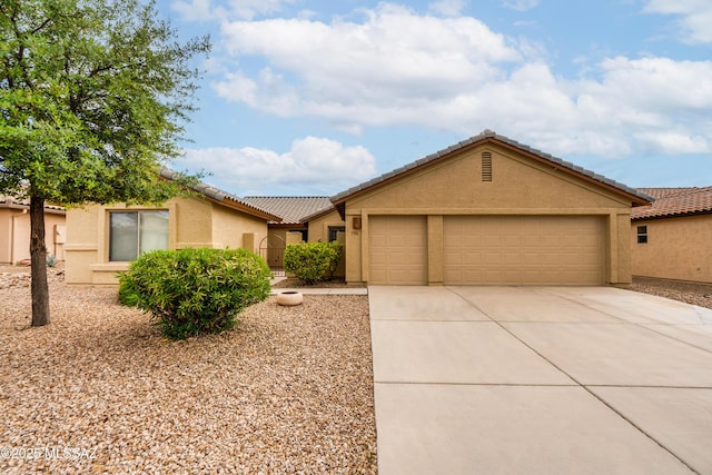 single story home with a garage, a tile roof, driveway, and stucco siding