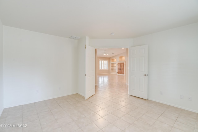 spare room with visible vents, baseboards, and light tile patterned floors