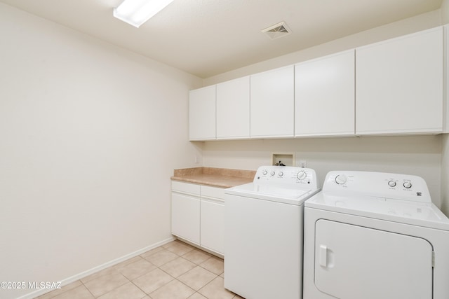 laundry room featuring visible vents, light tile patterned floors, independent washer and dryer, baseboards, and cabinet space